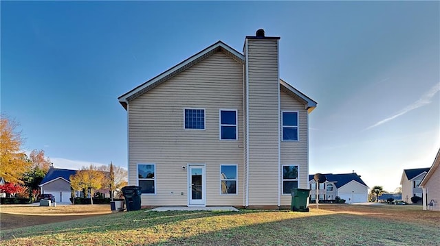 back of property featuring a chimney and a yard