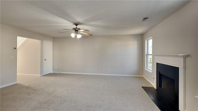 unfurnished living room with visible vents, baseboards, carpet, and a textured ceiling