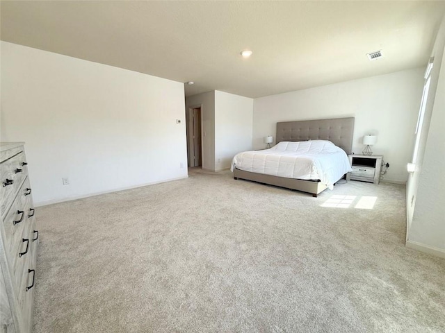 bedroom featuring visible vents, light colored carpet, and baseboards