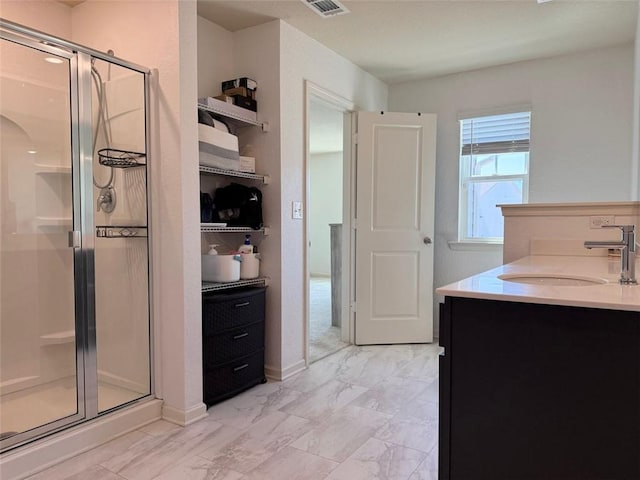 bathroom with vanity, visible vents, marble finish floor, a stall shower, and baseboards