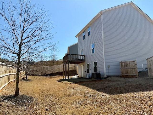 back of property featuring central AC and fence