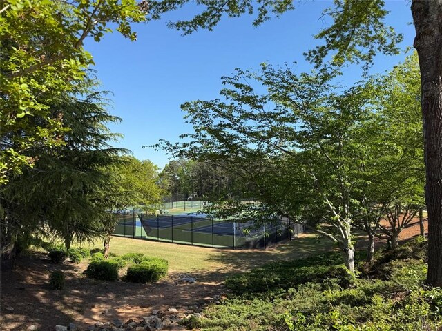 view of tennis court featuring fence