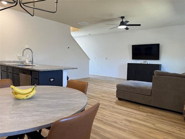 dining area with visible vents, light wood-type flooring, and ceiling fan with notable chandelier