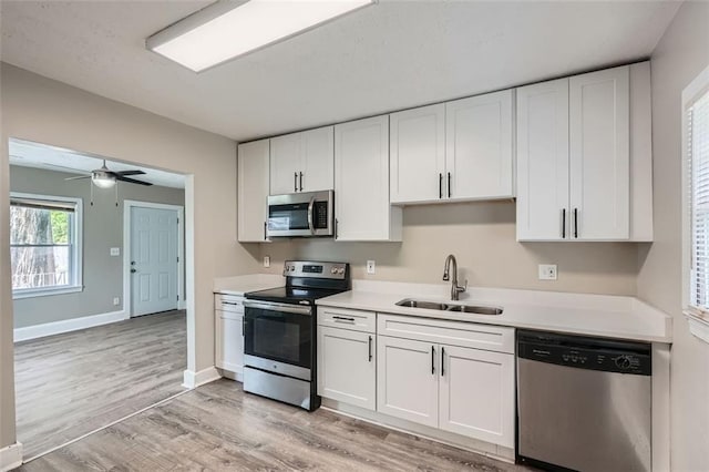 1002 Ira St SW, Atlanta, GA 30310 - kitchen featuring light wood-style floors, light countertops, white cabinetry, a sink, and stainless steel appliances