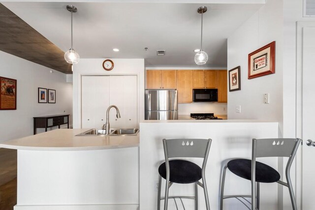 845 Spring St Unit 125, Atlanta, GA 30308 - kitchen with freestanding refrigerator, black microwave, a sink, a kitchen bar, and recessed lighting