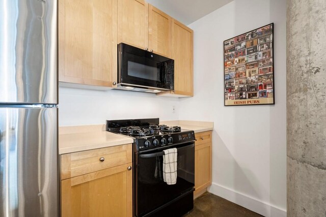 845 Spring St Unit 125, Atlanta, GA 30308 - kitchen featuring black appliances, light brown cabinets, baseboards, and light countertops