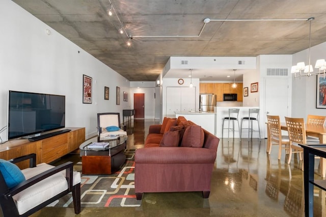 845 Spring St Unit 125, Atlanta, GA 30308 - living room with finished concrete flooring, rail lighting, and a chandelier