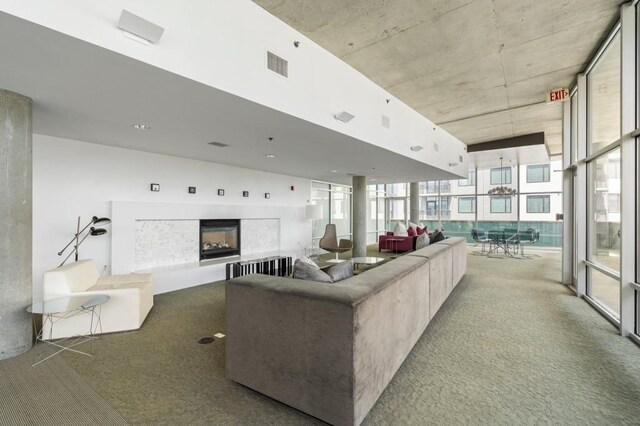 845 Spring St Unit 125, Atlanta, GA 30308 - carpeted living area featuring a glass covered fireplace and a wall of windows
