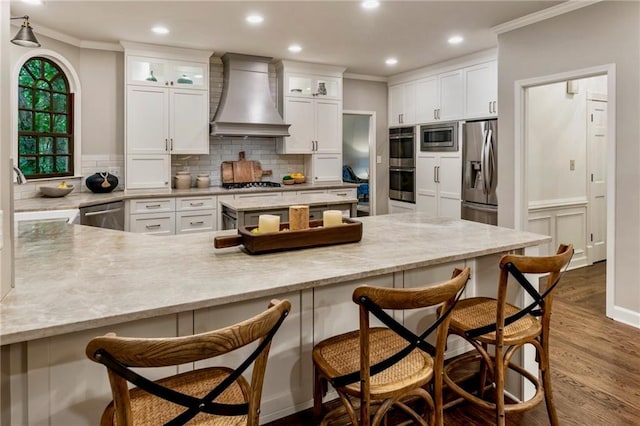 3275 Lord N Lady Ln, Alpharetta, GA 30022 - kitchen with custom exhaust hood, stainless steel appliances, ornamental molding, a kitchen bar, and backsplash