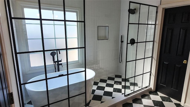 bathroom featuring tile patterned floors, a freestanding bath, and a walk in shower