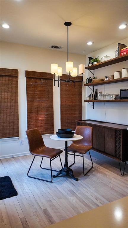 dining area with light wood-style flooring, a notable chandelier, recessed lighting, and visible vents