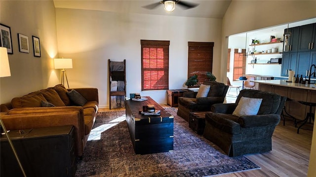 living area featuring lofted ceiling, wood finished floors, and ceiling fan