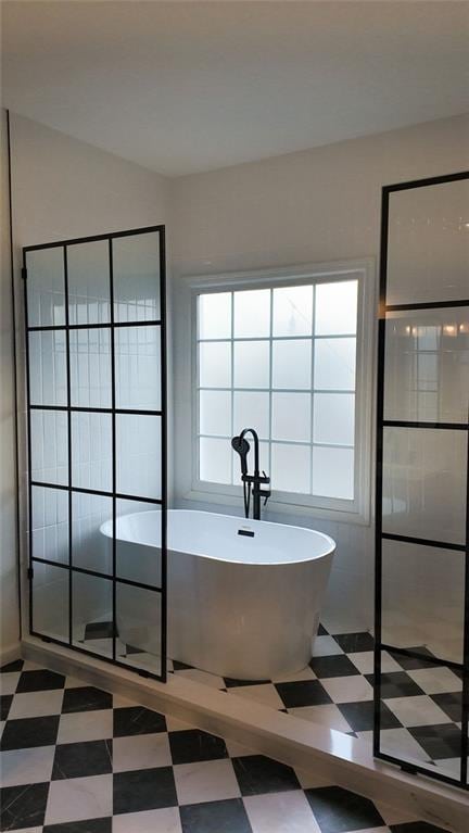 bathroom with tile patterned floors, a freestanding tub, and walk in shower