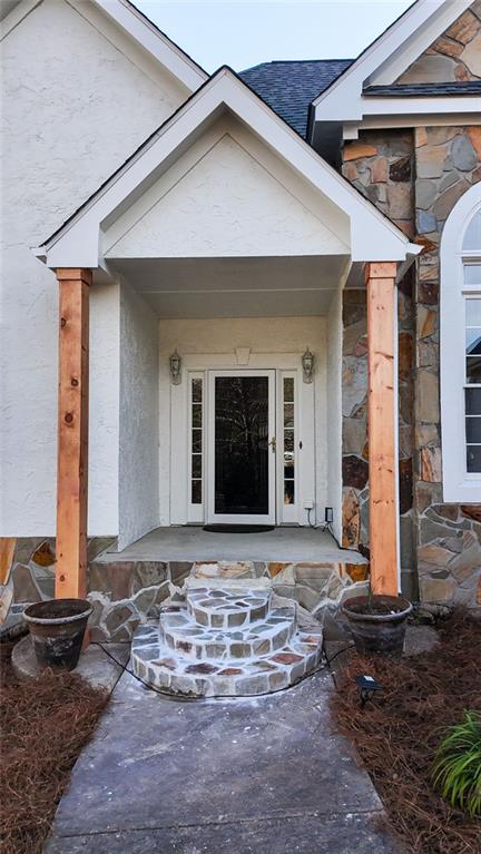 view of exterior entry featuring stucco siding