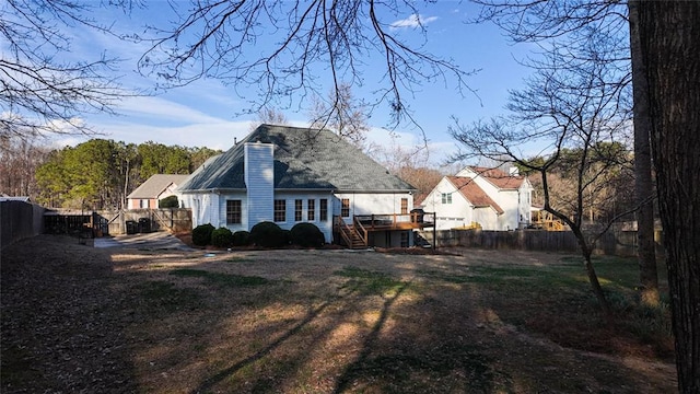 rear view of property with stairway, a deck, a fenced backyard, and a chimney