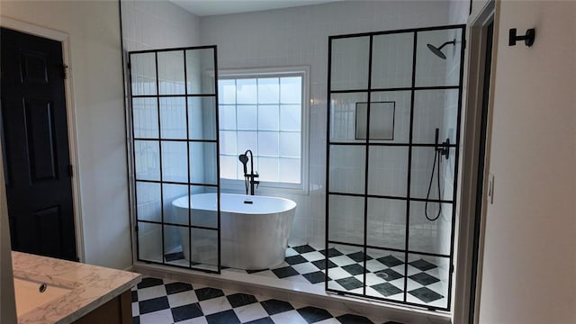 full bath with a freestanding bath, tile patterned floors, vanity, and walk in shower