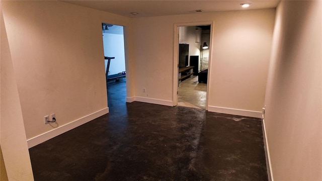 empty room featuring visible vents, concrete floors, and baseboards