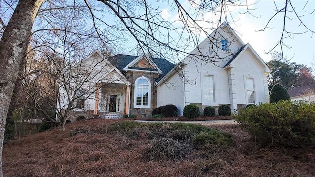 view of front of home featuring stone siding and stucco siding