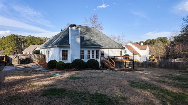 rear view of house with a gate, fence, a wooden deck, a chimney, and stairs