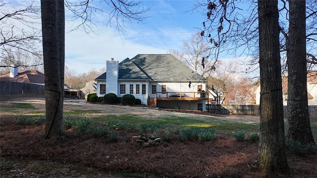 back of property with stairs, fence, a chimney, and a wooden deck