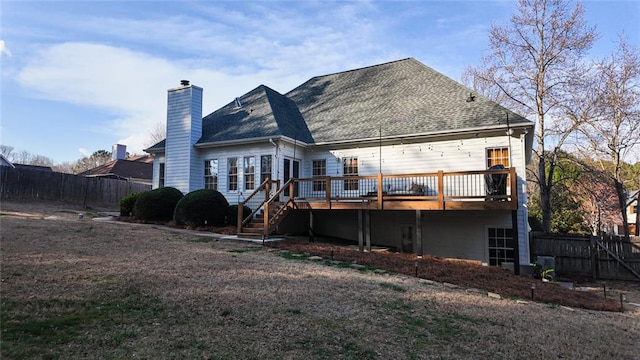 back of property featuring fence, stairway, a shingled roof, a wooden deck, and a chimney