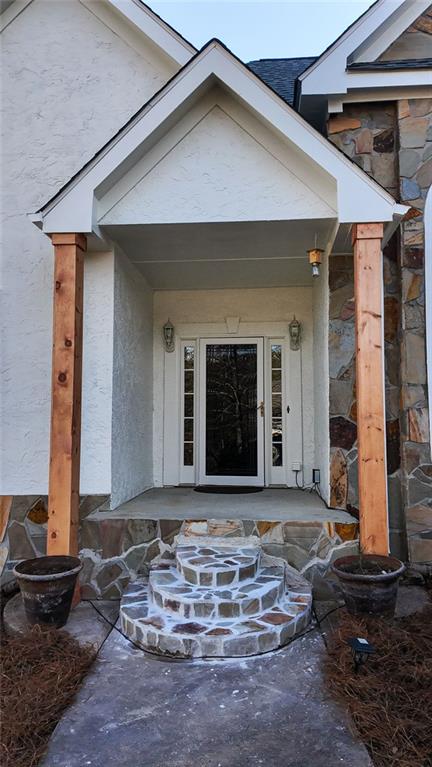 entrance to property featuring stucco siding