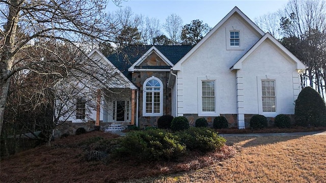 traditional-style house featuring stone siding and stucco siding