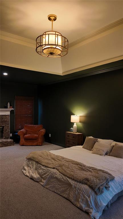 carpeted bedroom featuring a fireplace and crown molding