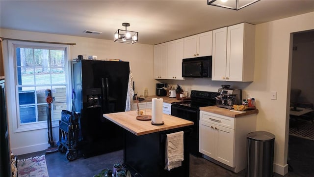 kitchen with wood counters, black appliances, white cabinets, and visible vents