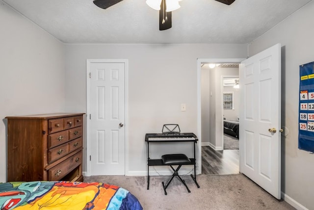 carpeted bedroom with baseboards, a textured ceiling, and ceiling fan