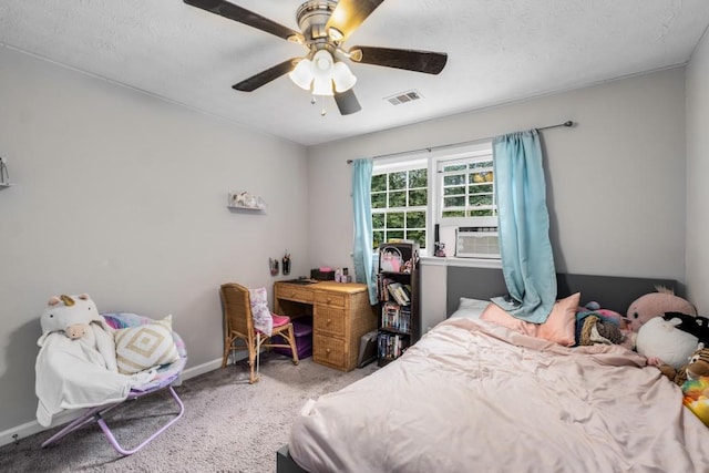 carpeted bedroom with visible vents, baseboards, ceiling fan, cooling unit, and a textured ceiling