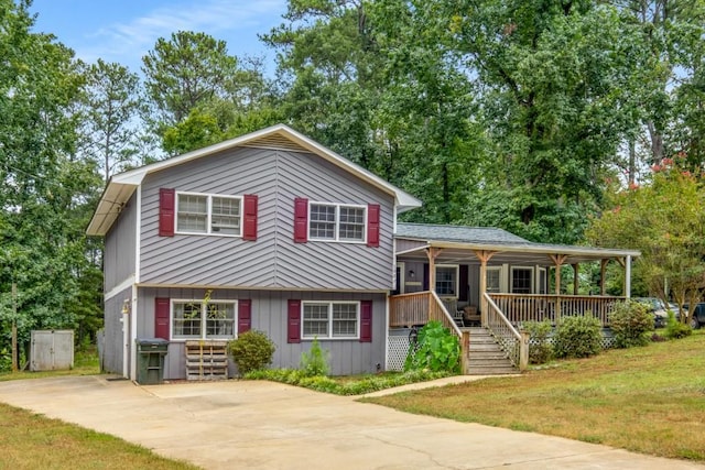 split level home with a porch, concrete driveway, and a front lawn