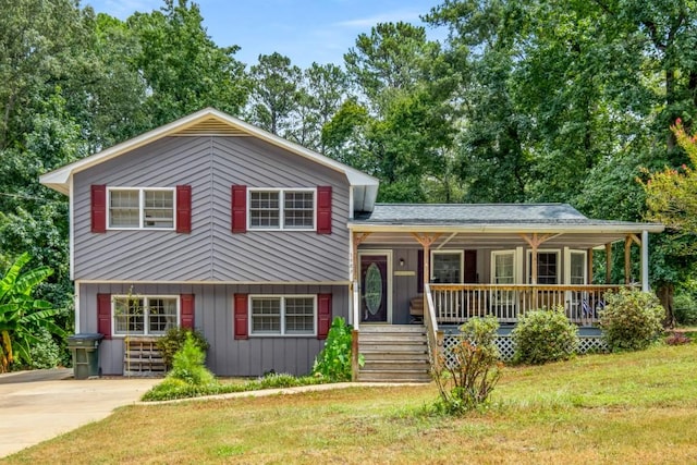 tri-level home featuring a front lawn, board and batten siding, a porch, and driveway