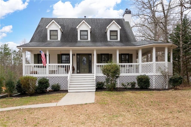 view of front of home with a shingled roof, a front lawn, and a porch