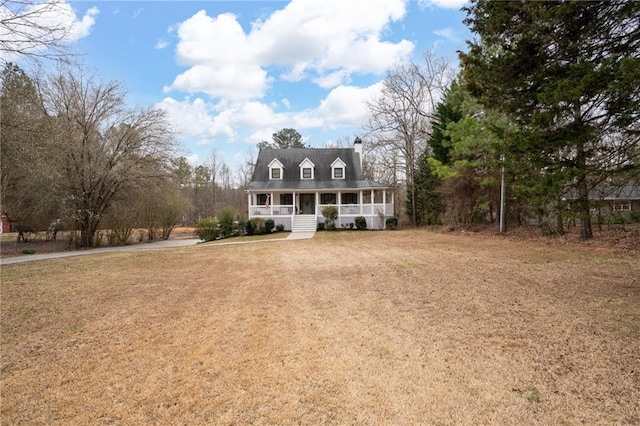 new england style home with a porch and a front lawn