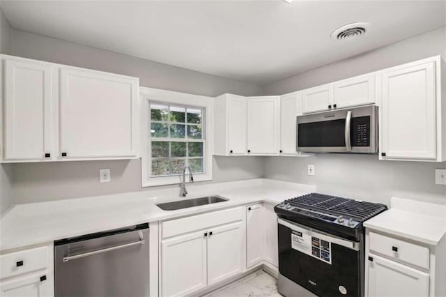 kitchen featuring white cabinetry, sink, and appliances with stainless steel finishes