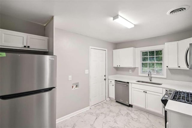 kitchen with white cabinets, appliances with stainless steel finishes, and sink