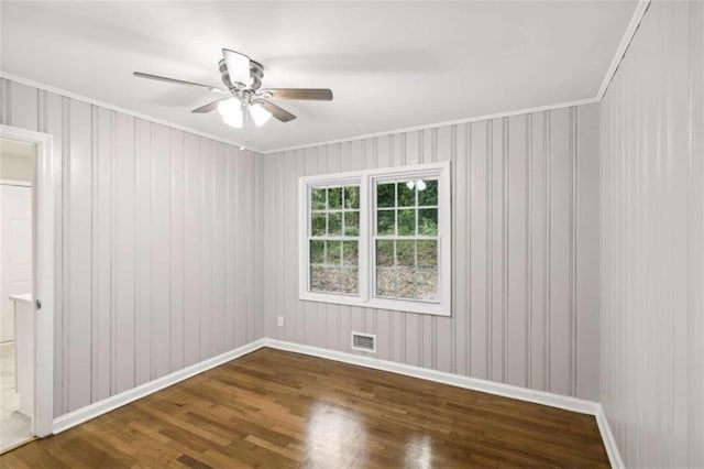 unfurnished room featuring ceiling fan, crown molding, and dark wood-type flooring