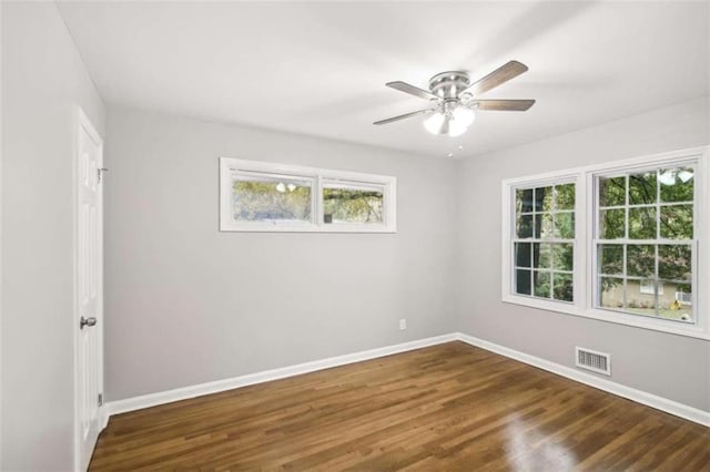 spare room with dark hardwood / wood-style flooring and ceiling fan