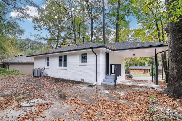 rear view of house with a carport and cooling unit