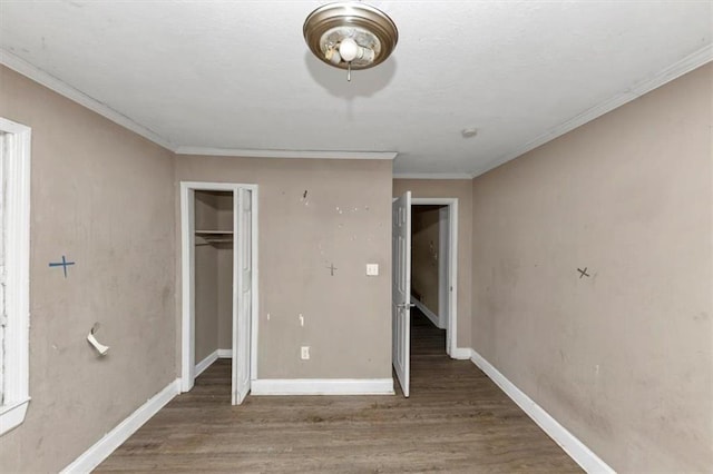 unfurnished bedroom featuring crown molding, dark wood-type flooring, and a closet