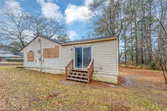 rear view of property featuring a lawn