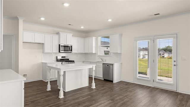 2939 Champions Way, Loganville, GA 30052 - kitchen featuring appliances with stainless steel finishes, dark wood finished floors, white cabinetry, backsplash, and crown molding