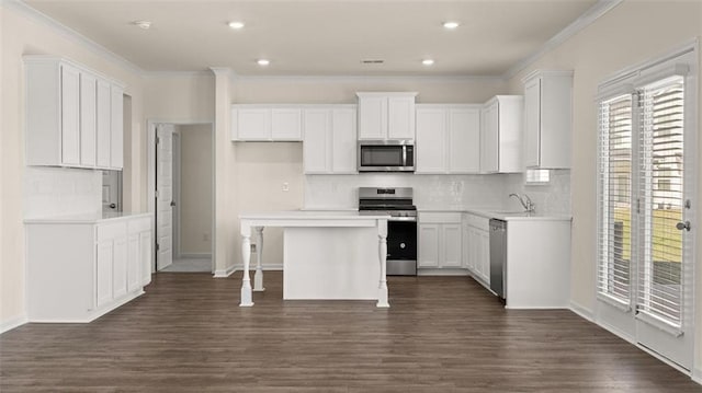 2939 Champions Way, Loganville, GA 30052 - kitchen featuring stainless steel appliances, backsplash, ornamental molding, white cabinets, and a kitchen island