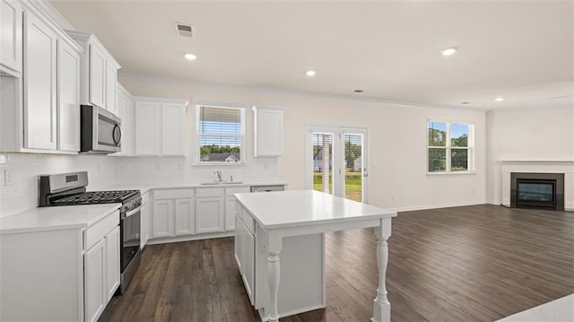 2939 Champions Way, Loganville, GA 30052 - kitchen featuring stainless steel appliances, dark wood-type flooring, open floor plan, tasteful backsplash, and a kitchen island