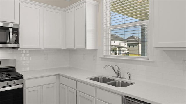2939 Champions Way, Loganville, GA 30052 - kitchen with appliances with stainless steel finishes, white cabinetry, light countertops, and decorative backsplash