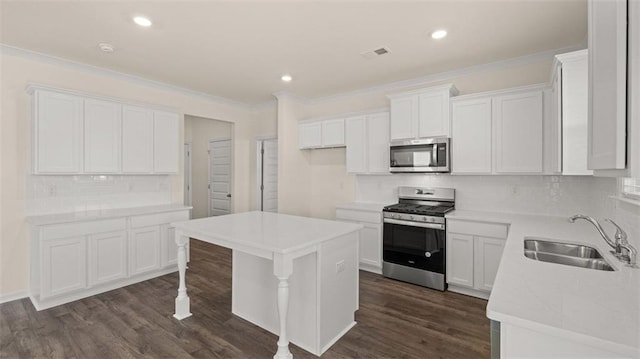 2939 Champions Way, Loganville, GA 30052 - kitchen with appliances with stainless steel finishes, ornamental molding, backsplash, dark wood finished floors, and white cabinetry