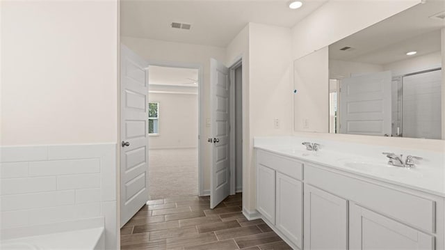 2939 Champions Way, Loganville, GA 30052 - bathroom with double vanity, wood finished floors, recessed lighting, and a bath
