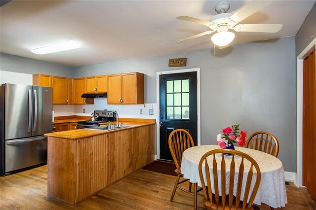 dining space with light wood-type flooring and ceiling fan