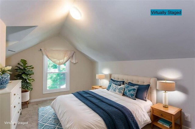 carpeted bedroom with lofted ceiling and baseboards